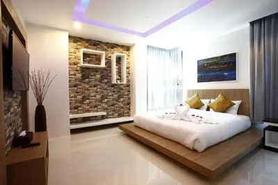 a bedroom with a large white bed with a window at Buasri By Ohm in Patong Beach