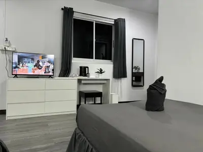 a bedroom with a bed and a dresser with a television at White House in Phi Phi Don