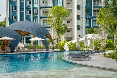 a pool at a hotel with chairs and umbrellas at Title Halo Andaman Coast Pool View Gym in Nai Yang Beach
