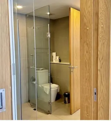 a bathroom with a toilet and a glass shower door at Oceanstone condo Bangtao Beach in Bang Tao Beach