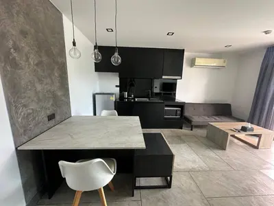 a kitchen and living room with a table and chairs at Modern apartment on Naiharn Beach B404 in Rawai Beach
