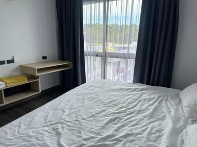 a bedroom with a bed and a large window at Modern apartment on Naiharn Beach B404 in Rawai Beach