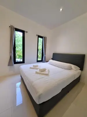 a bedroom with a large bed with two towels on it at Nua tone riverside resort in Ban Thalat Choeng Thale