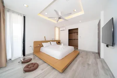 a bedroom with a white bed and a flat screen tv at \u9038\u6d77\u306e\u5922 Laguna\u4e09\u5367\u5ba4\u79c1\u4eba\u6cf3\u6c60\u522b\u5885 in Ban Phru Champa