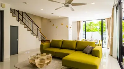 a living room with a green couch and a ceiling fan at Laguna Park 2 Family Pool Villa near Bang Tao Beach in Bang Tao Beach