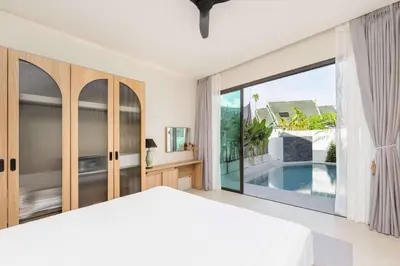 a bedroom with a bed and a view of a pool at Villa Plunge Modern 2-Bedroom with Private Pool in Rawai Beach