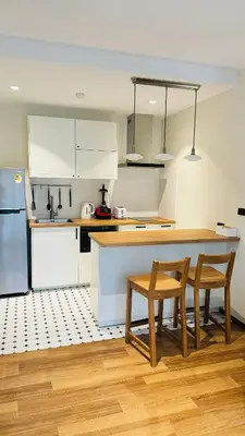 a kitchen with white cabinets and a table and chairs at The Title Halo 1 Naiyang beach in Nai Yang Beach