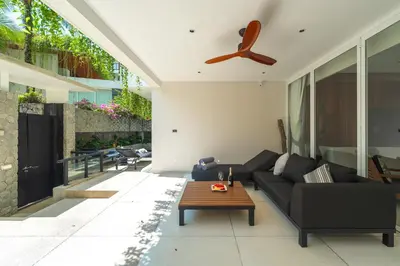 a living room with a black couch and a table at Private Pool Residence at Surin Beach in Surin Beach