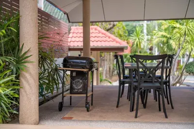a grill on a table and chairs on a patio at Coast Charm 6BR House Karon in Karon Beach