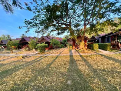 a group of houses with their shadows on the grass at Koh Yao Seaview Bungalow in Ko Yao Noi