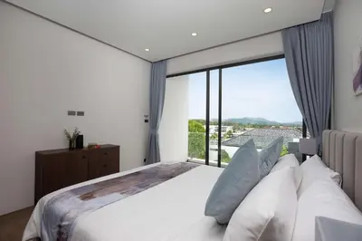 a bedroom with a large bed with a large window at Ultra-Modern Tropical Pool Villa in Phuket