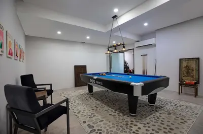 a living room with a pool table and a chair at Ultra-Modern Tropical Pool Villa in Phuket