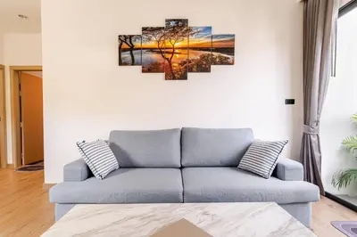 a living room with a couch and a painting on the wall at Oasis by the Sea M2- House with Pool and Amenities in Phuket Town