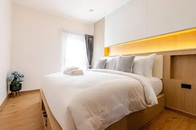 a large white bed in a room with a window at Oasis by the Sea M3- House with Pool and Amenities in Phuket Town