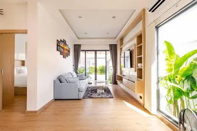 a living room with a chair and a bed at Oasis by the Sea M3- House with Pool and Amenities in Phuket Town