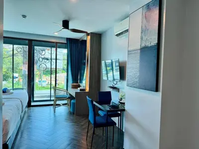 a hotel room with a bed and a desk and chairs at Deluxe Twin Bed Apartment by Renttini in Kamala Beach