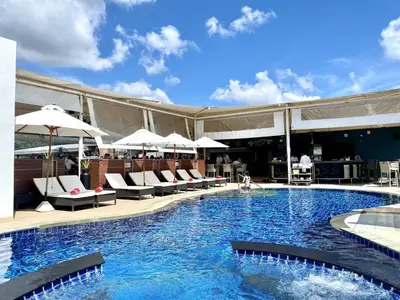 a swimming pool with chairs and umbrellas on a building at Patong - Studio Condo - Absolute Bangla Unit in Patong Beach