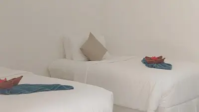 two white beds sitting next to each other in a room at Bung Bud Garden Bungalows & Homestay - Koh Yao Noi in Phangnga
