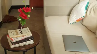 a table with books and a laptop on a couch at Bung Bud Garden Bungalows & Homestay - Koh Yao Noi in Phangnga