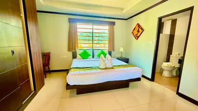 a bedroom with a large bed and a bathroom at KS Residence Patong in Patong Beach