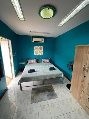 a bedroom with a bed in a blue wall at Ciao Bella GuestHouse & Bistro in Kata Beach