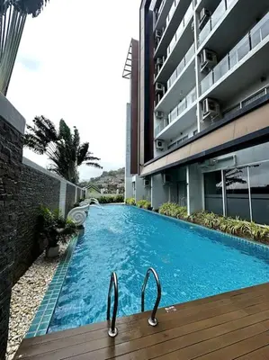 a swimming pool in front of a building at Сhic condo студия с бассейном in Karon Beach