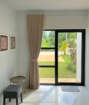 a room with a large window with a chair and a table at Krabi Private Pool Villa 2 by Belcarra Spaces in Ban Khlong Haeng