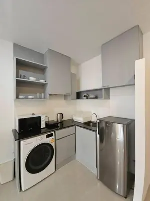 a kitchen with a washing machine and a refrigerator at Chic condominium karon beach in Karon Beach