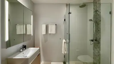 a bathroom with a glass shower and a sink at Cozy apartment with a Resort Facilities in Bangtao in Bang Tao Beach