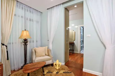 a living room with a chair and a table at Golden Lily 4 Bedroom Private Pool Villa in Rawai Beach