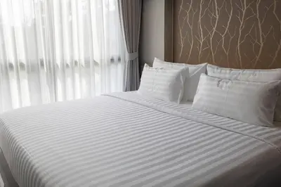 a bed with white sheets and pillows next to a window at 600m to beach New City gate P214 #c60 in Kamala Beach