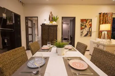 a dining room with a table with plates and wine glasses at Most Beautiful Relaxation Garden Villa V86 in Rawai Beach