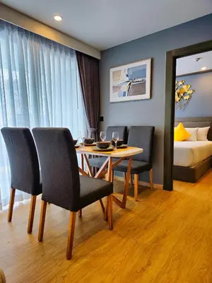 a dining room with a table and chairs and a bed at 2 BDR Suite in 5 Star Hotel in Rawai Beach