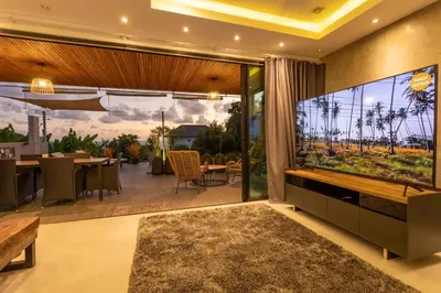 an open living room with a large tv and a patio at 4 Big Separate Apartments SeaView 8KingBeds v104 in Karon Beach