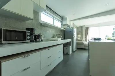a kitchen with white cabinets and a microwave at 4 Big Separate Apartments SeaView 8KingBeds v104 in Karon Beach