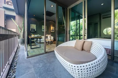 a bedroom with a wicker couch on a balcony at Saturdays by Lotus Heart in Ban Saiyuan (1)