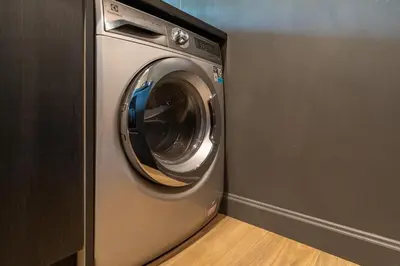 a washing machine in a corner of a room at Saturdays by Lotus Heart in Ban Saiyuan (1)
