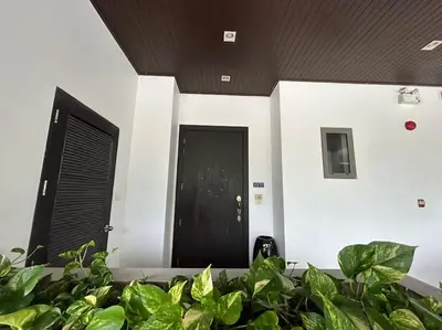 a black door in a room with green plants at A lovely 2-3 bed only 300m walk to Bangtao Beach in Phuket