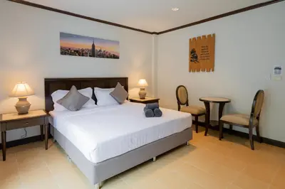 a bedroom with a bed and a table and chairs at Tri's Miracle Apartment Kata in Kata Beach