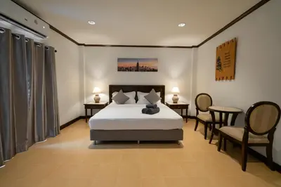 a bedroom with a bed and a table and chairs at Tri's Miracle Apartment Kata in Kata Beach