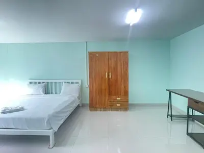 a bedroom with a bed and a wooden cabinet at SHERRY'S Guest House in Patong Beach