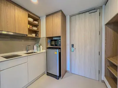 a kitchen with a refrigerator and a door in it at Skypark private new apartmant in Phuket