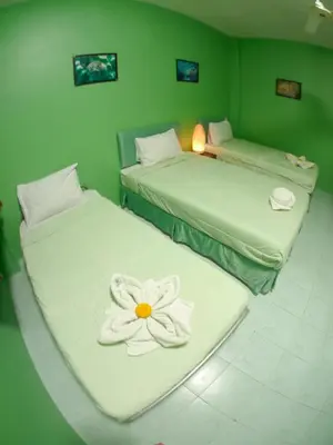 two beds with a flower on them in a room at Adams house in Patong Beach
