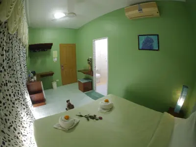 a green room with a table with towels on it at Adams house in Patong Beach
