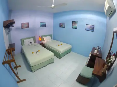 a room with two beds in a blue room at Adams house in Patong Beach