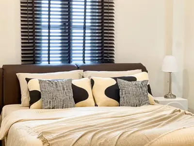 a bed with black and white pillows and a window at 4BR Patong Pool Villa, Sleeps 8 in Patong Beach