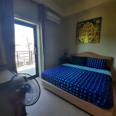 a bedroom with a bed and a fan and a window at Naiharn high view villa in Rawai Beach