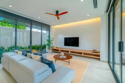a living room with a white couch and a tv at Sava Villa near Rawai in Ban Saiyuan (1)