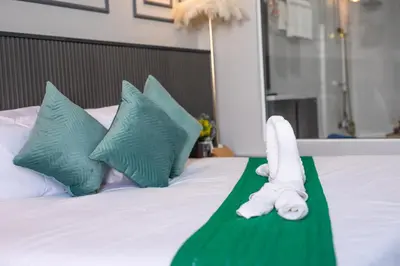 a towel animal laying on a bed with pillows at Best Time Pool Suites in Chalong