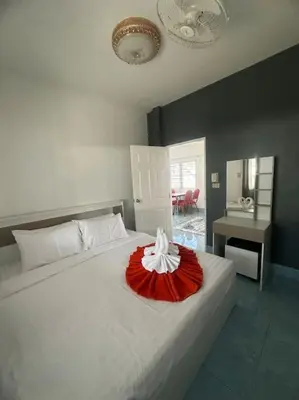 a bedroom with a white bed with a red dress on it at P&I Group Home 4 Karon beach in Karon Beach